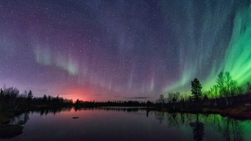 Scenic view of lake against sky at night