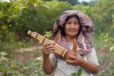 Dusun ethnic grandma , sabah, plays traditional bamboo musical instruments 