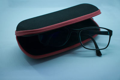 Close-up of sunglasses on table against blue background