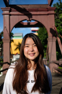 Portrait of smiling young woman standing outdoors