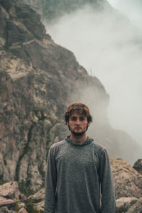 Portrait of young man standing on mountain