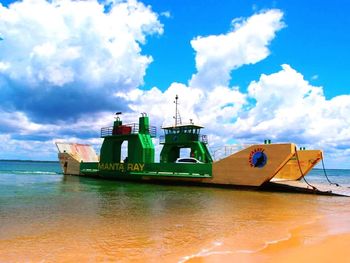 Boats in sea against cloudy sky