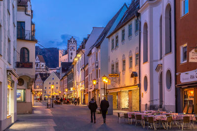 People walking on street amidst buildings in city