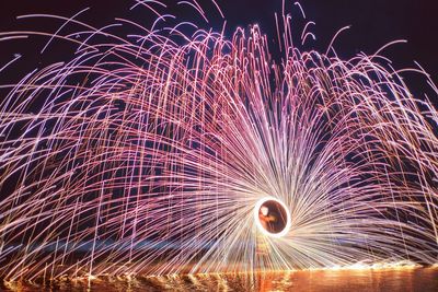 Close-up of person spinning wire wool at night