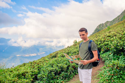 Young man standing against sky