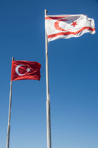 Low angle view of flag against blue sky