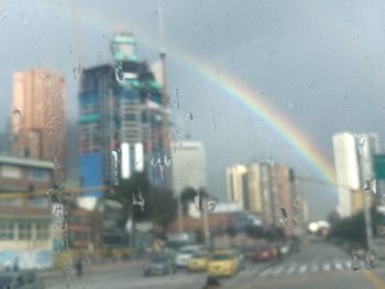 Buildings seen through wet glass window in rainy season