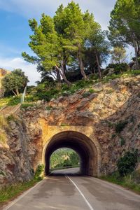 Road leading towards arch bridge against sky