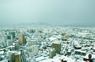 Aerial view of cityscape against clear sky during winter