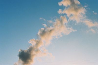 Low angle view of smoke stacks against blue sky