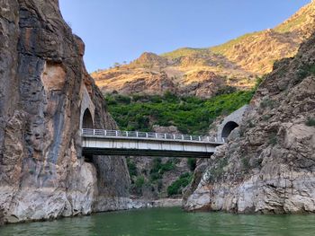 Arch bridge over mountain against sky