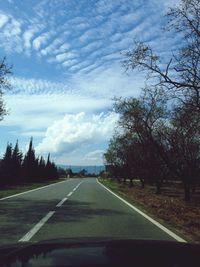 Empty road with trees in background