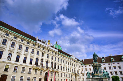 Low angle view of buildings against cloudy sky