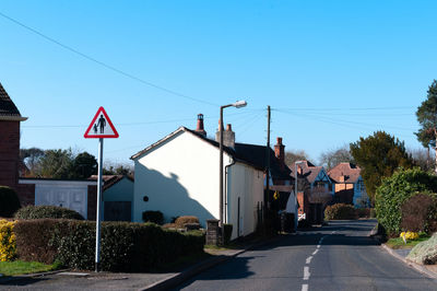 Triangular warning traffic sign beside road warning of pedestrians because no footpath 