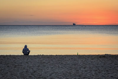 Silhouette man standing on beach against sky during sunset