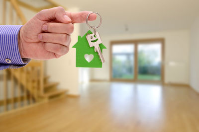 Cropped hand of man holding key at home