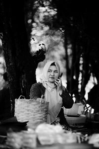 Portrait of woman holding food on table