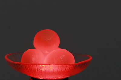 Close-up of red berries in bowl against black background