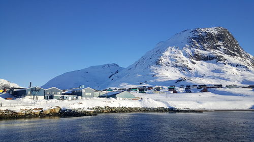 Scenic view of sea and mountains against clear blue sky