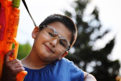 Portrait of young bot holding water gun