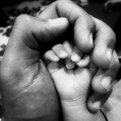 Close-up of parent holding baby's hands