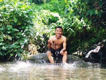 Portrait of shirtless man smiling in water