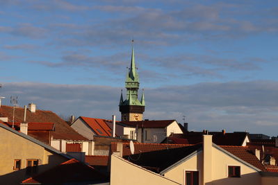 View of buildings in town against cloudy sky