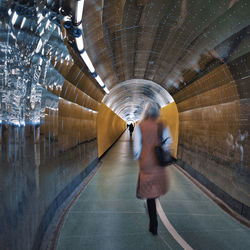 Man walking in illuminated tunnel