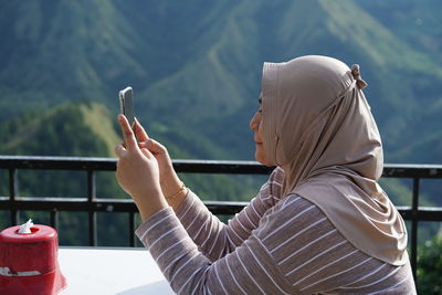 Rear view of man using mobile phone