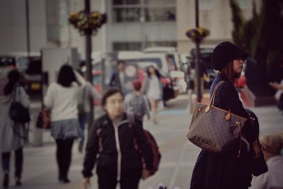 Rear view of people walking in city