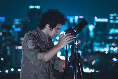 Man with camera standing at night