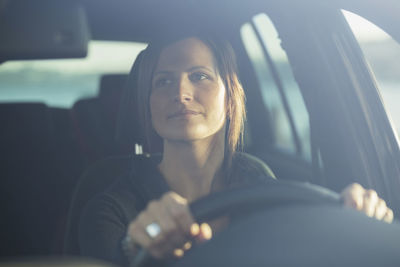 Young businesswoman driving car