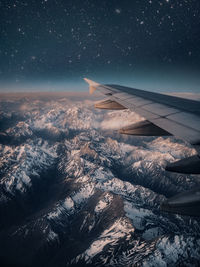 Aerial view of snowcapped mountains against star field at night