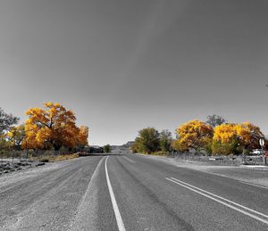 Road amidst trees against sky during autumn