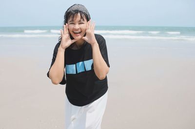 Portrait of young woman standing at beach