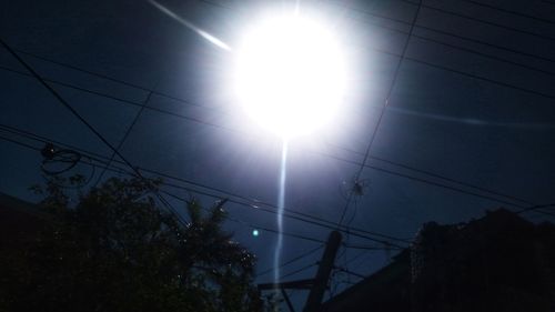 Low angle view of silhouette cables against sky