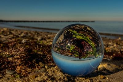 Close-up of crystal ball on beach