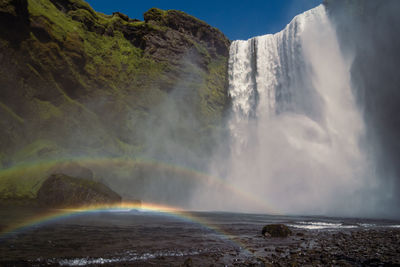 Rainbow near large waterfall landscape photo