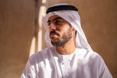 Portrait of arab man wearing dishdash kandura standing in historical disctrict