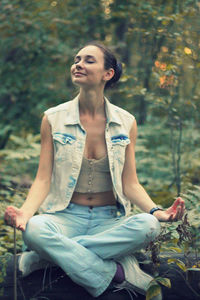 Full length of a smiling young woman sitting outdoors