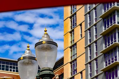 Low angle view of buildings against cloudy sky