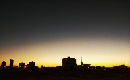 Silhouette buildings against sky during sunset