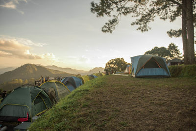 Tent on field against sky during sunset