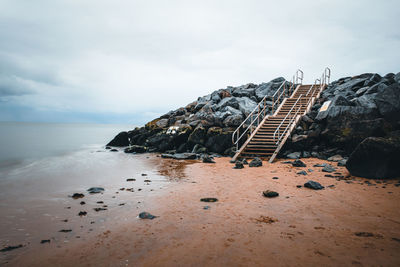 Scenic view of rocks on beach against sky