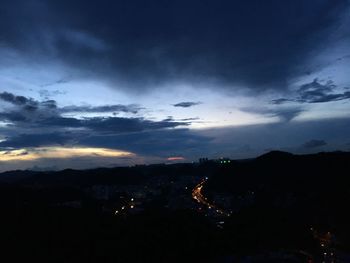 Aerial view of illuminated city against sky at sunset