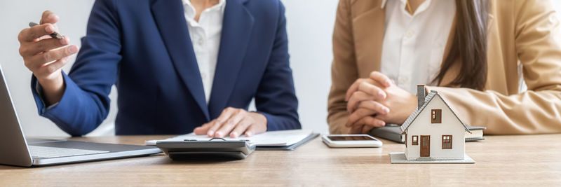 Midsection of estate agent having discussion with customer