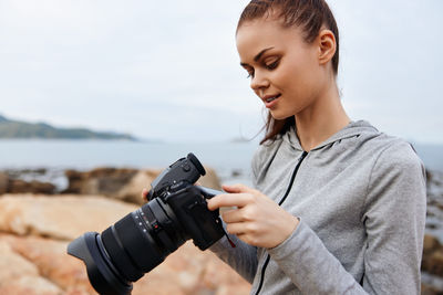 Young woman photographing with camera