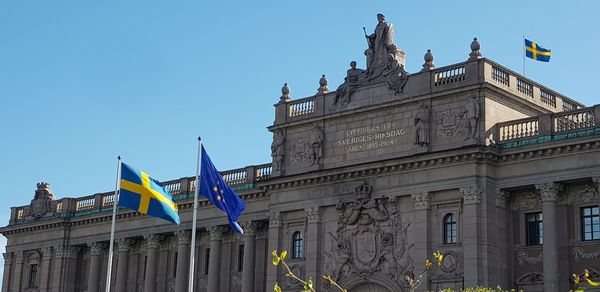 Low angle view of flags against clear sky