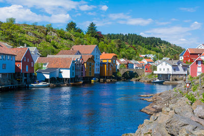 Houses by buildings against sky