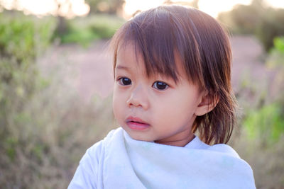 Close-up of cute girl looking away while standing outdoors